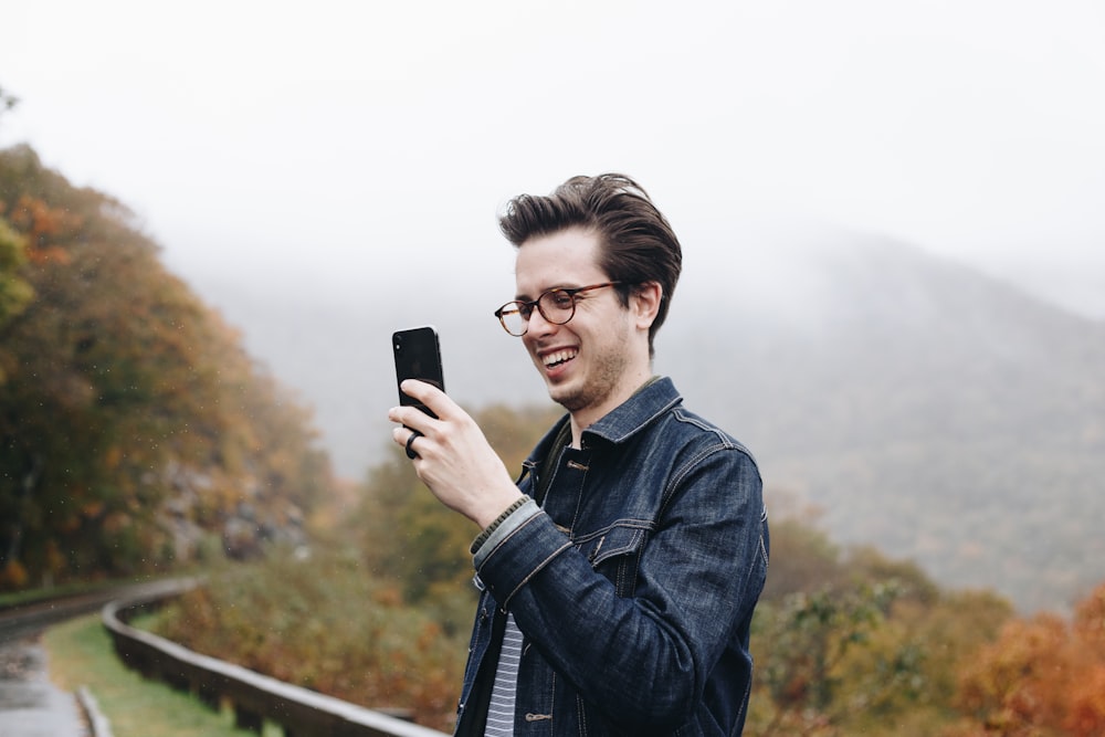 smiling man looking at his smartphone