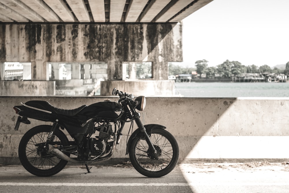 black standard motorcycle under the bridge