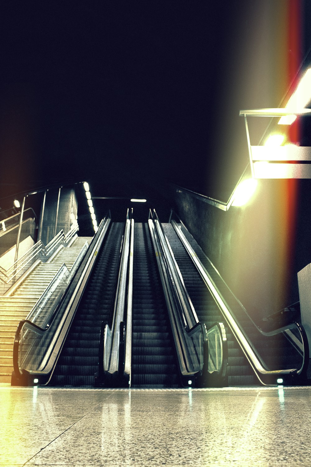 black escalator beside stair