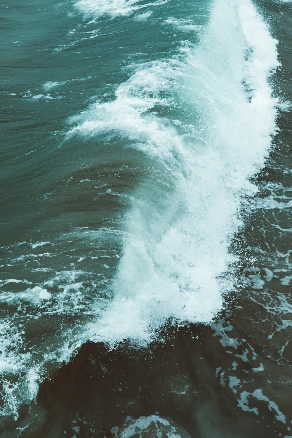 white and teal wave during daytime