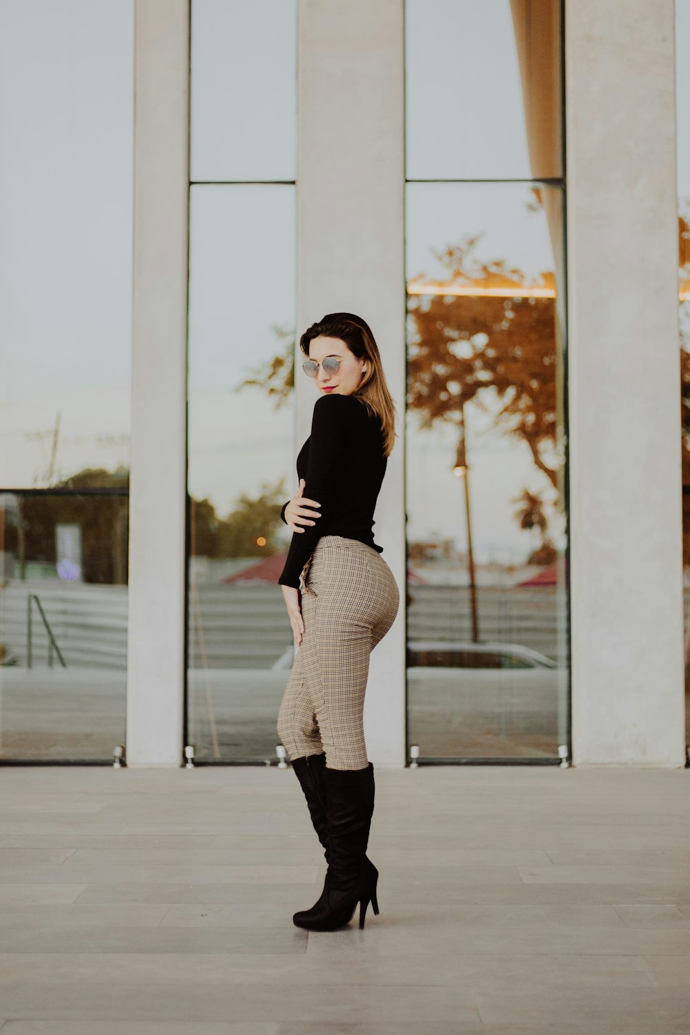 woman posing side ways near building