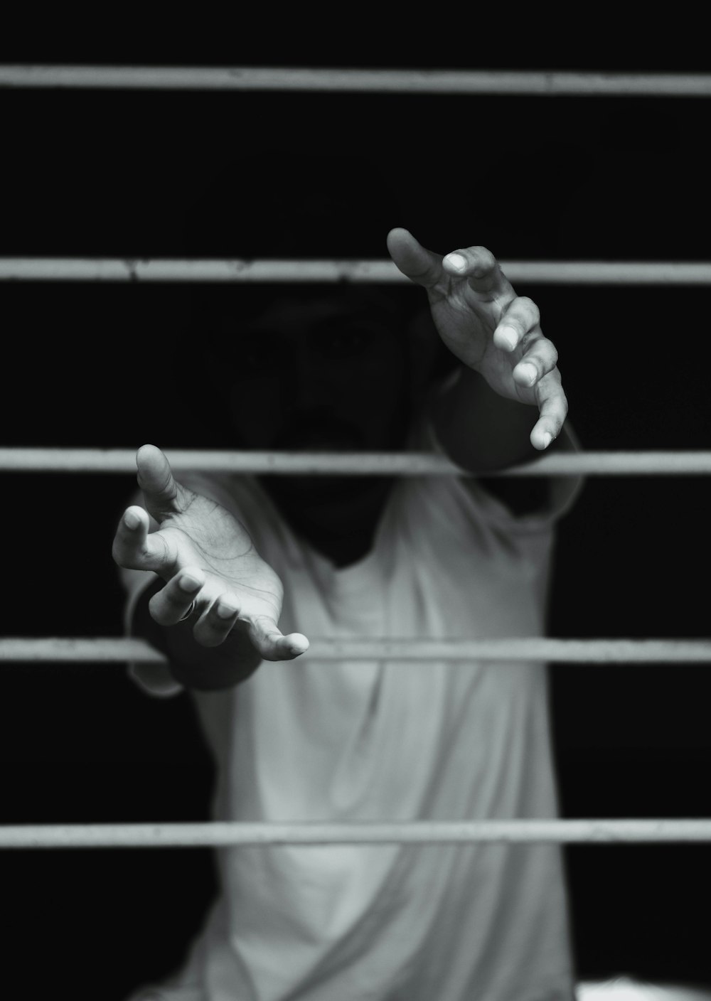 grayscale photography of man in front of window