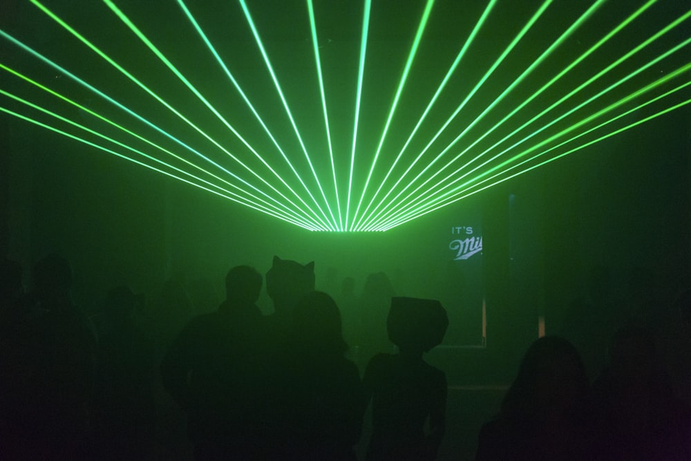 silhouette of people inside bar under green light