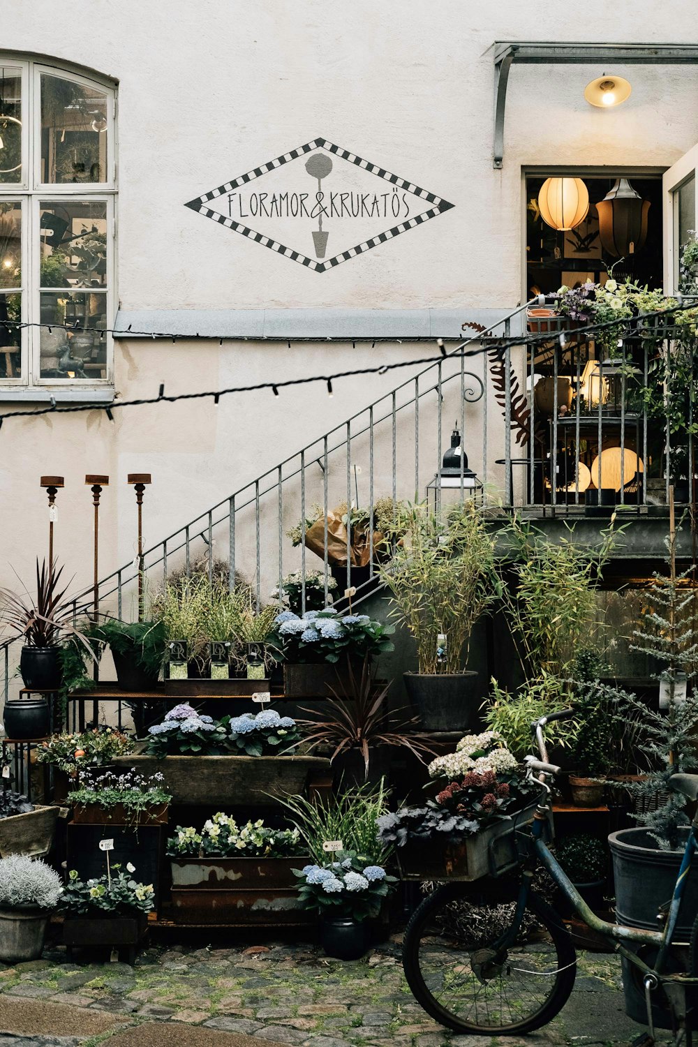 bicycle in front of potted paints under stairs