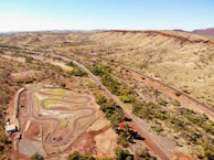 Aerial view of a winding desert racecourse lined with cheering spectators.