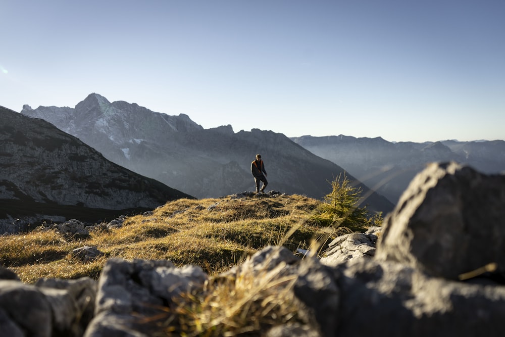 Persona in piedi sulla montagna rocciosa grigia