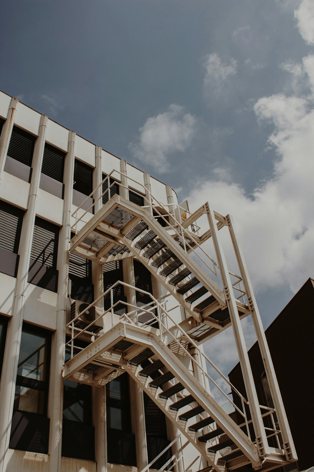 low-angle photography of staircase beside building during daytime