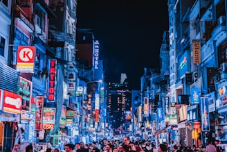 people between city buildings at night