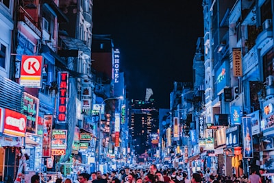 people between city buildings at night