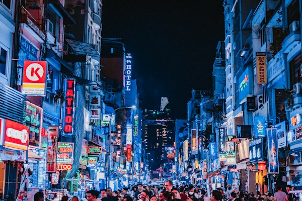 People between city buildings at night — Ho Chi Minh City, Vietnam