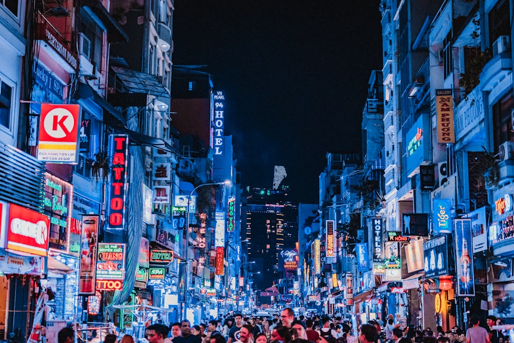 people between city buildings at night