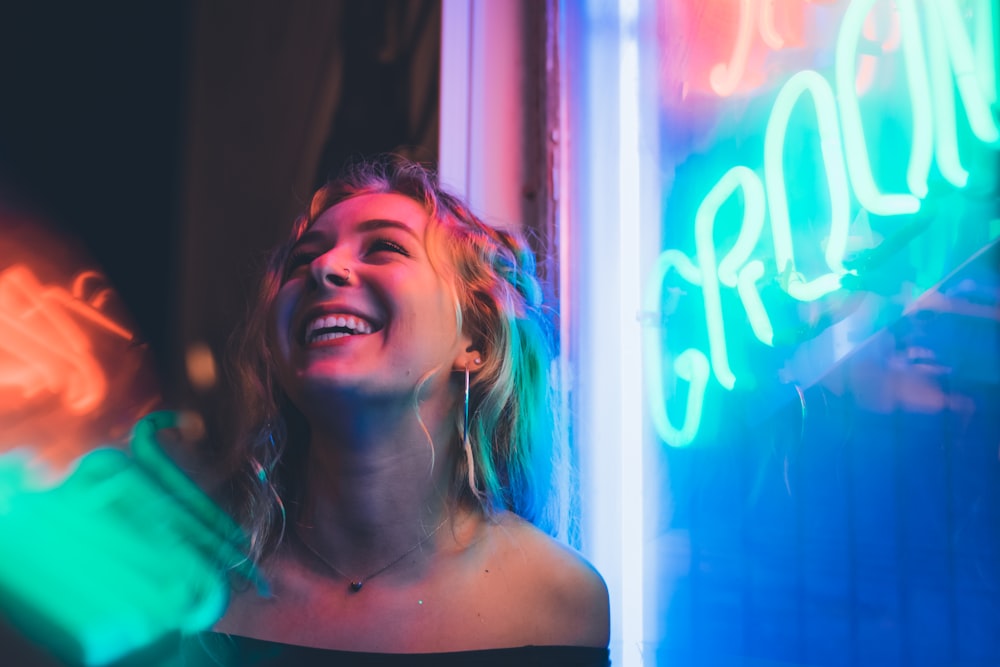 woman standing beside neon light