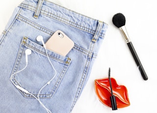 washed denim jeans and make-up brush