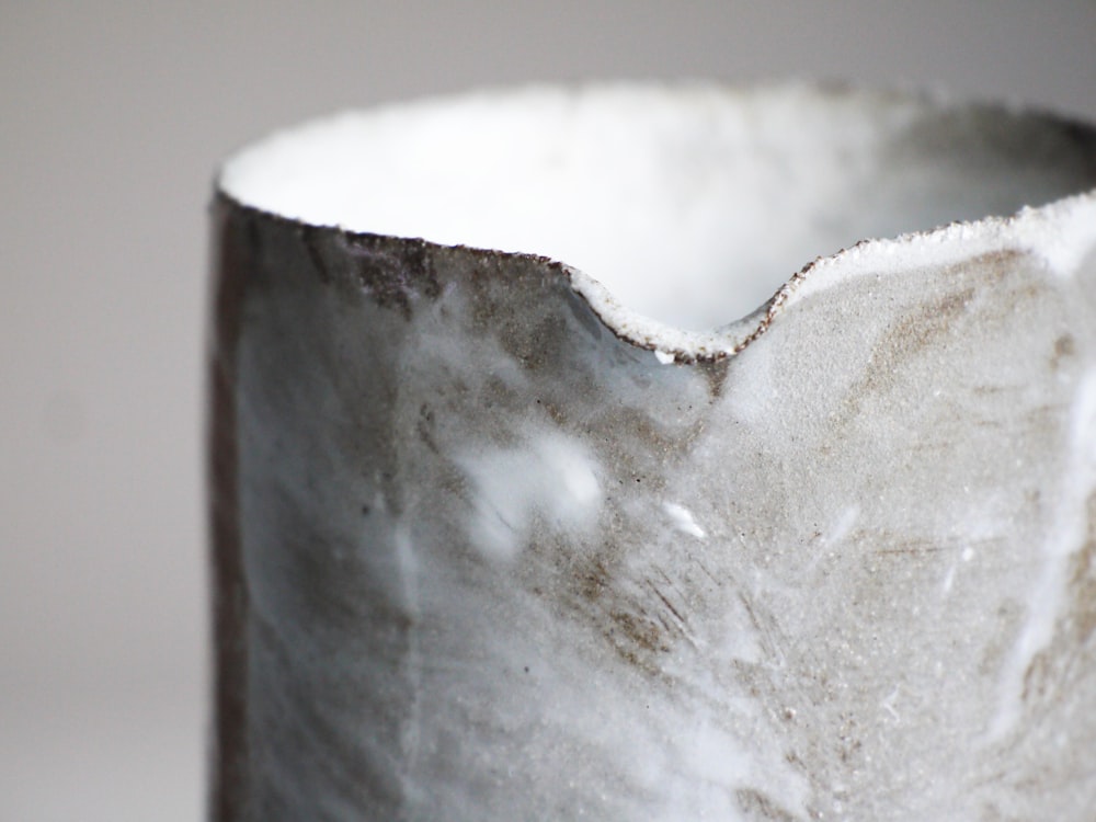 a close up of a white vase on a table