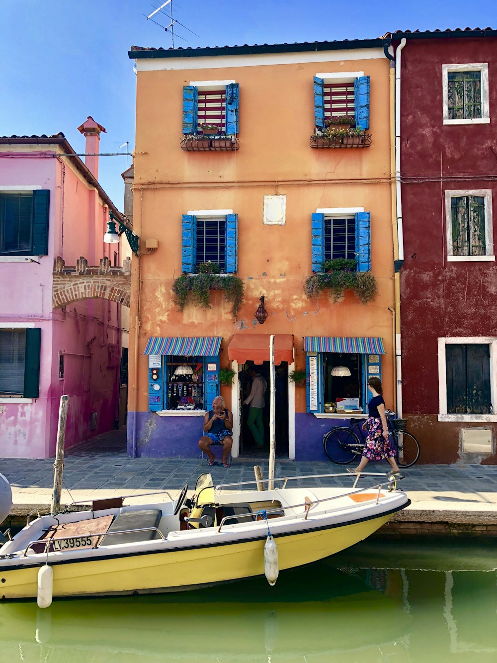 woman walking on dockside beside houses