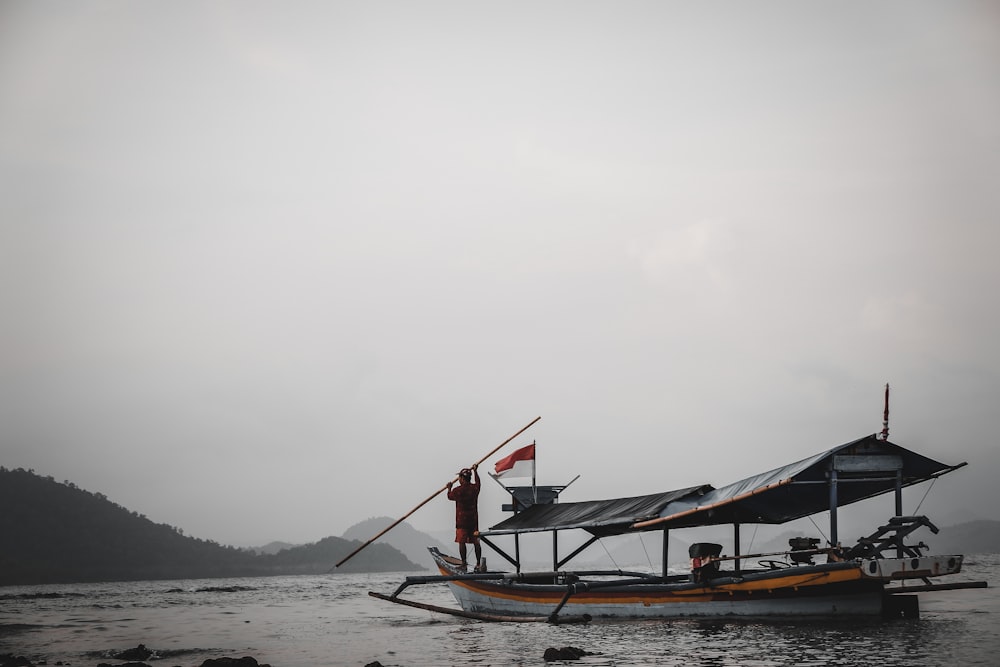 man standing on boat during foggy day