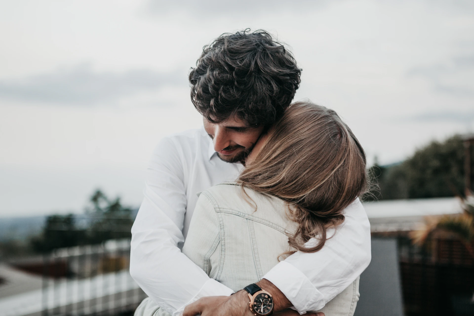 woman kissing man on neck
