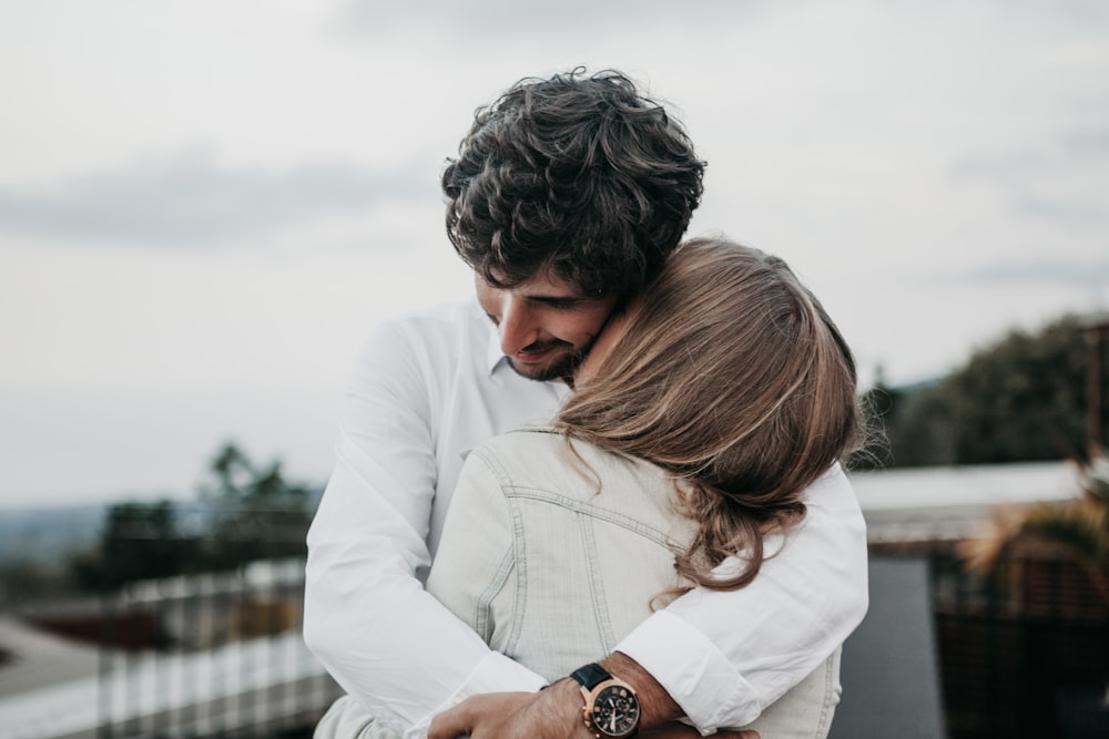 woman kissing man on neck