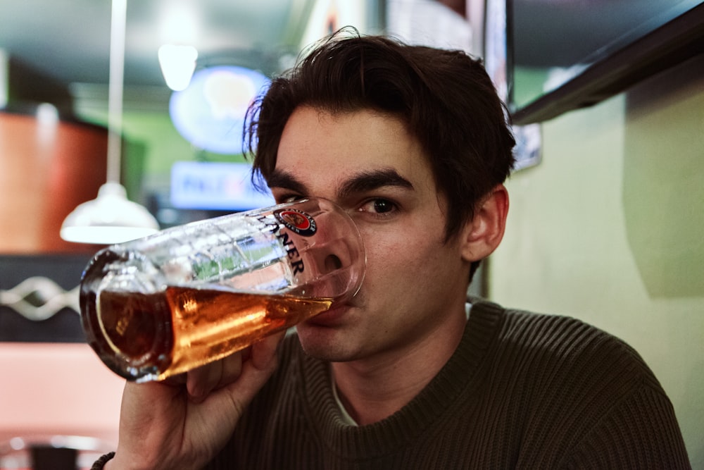 man drinking beer on selective focus photography
