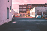 A quiet city alley at dawn, empty except for soft light casting long shadows, rendered in rich black and white.