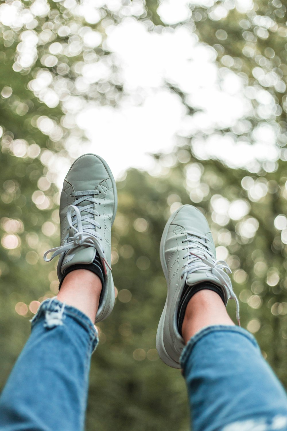 person showing gray shoes outdoors