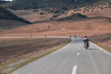 A group of motorcyclists riding through a scenic landscape.