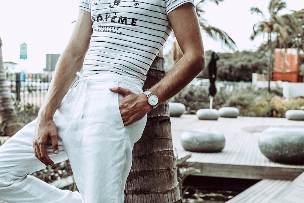 person in white pants wearing white analog watch