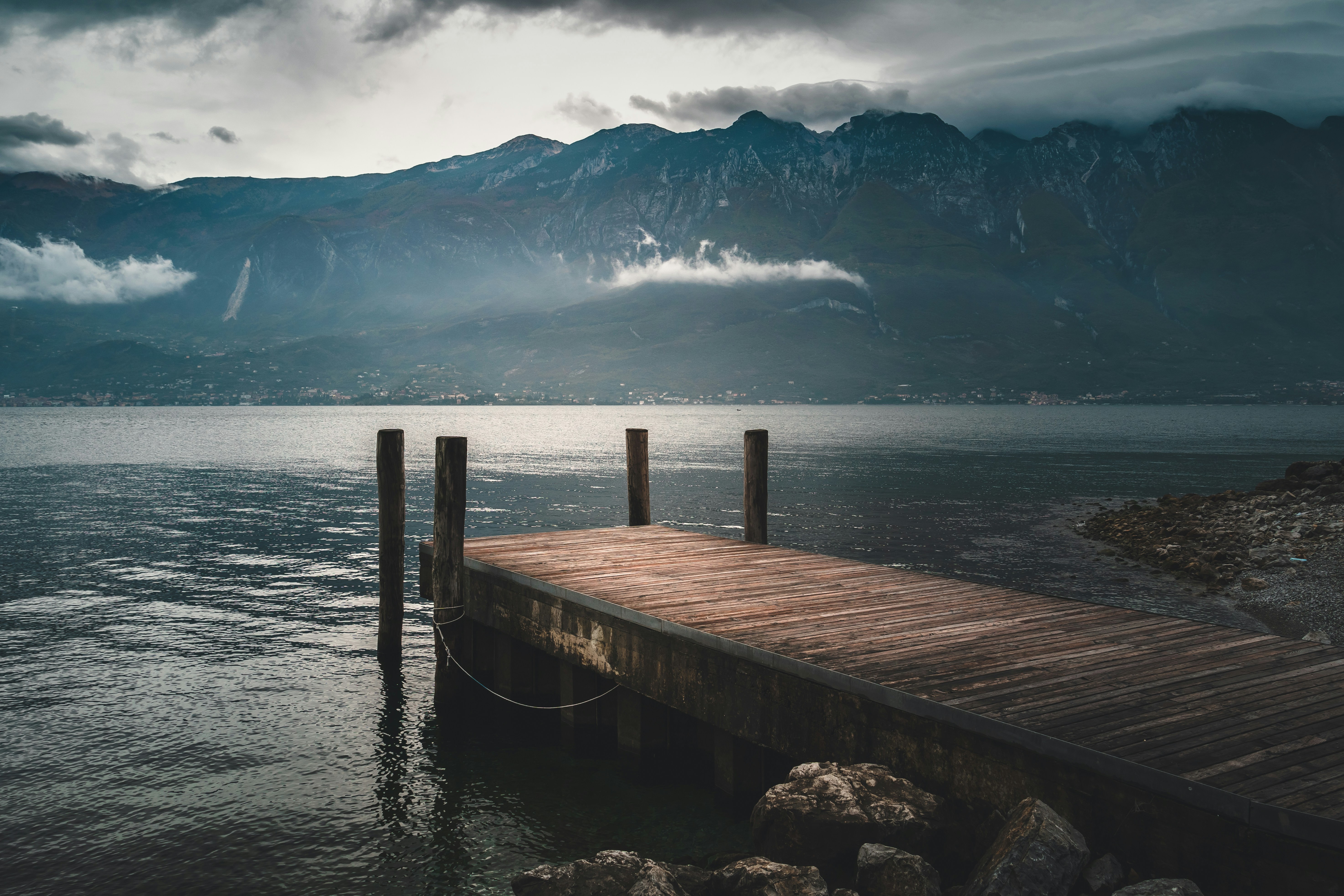 brown wooden dock near mountain, Bad weather on the Lake Garda