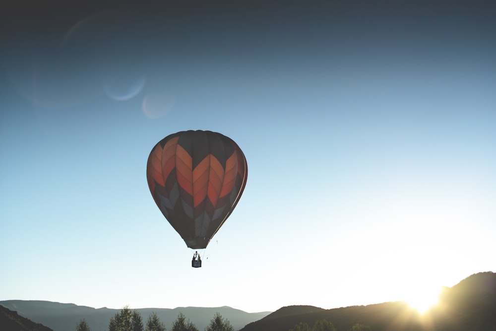 Roter und schwarzer Heißluftballon im Flug