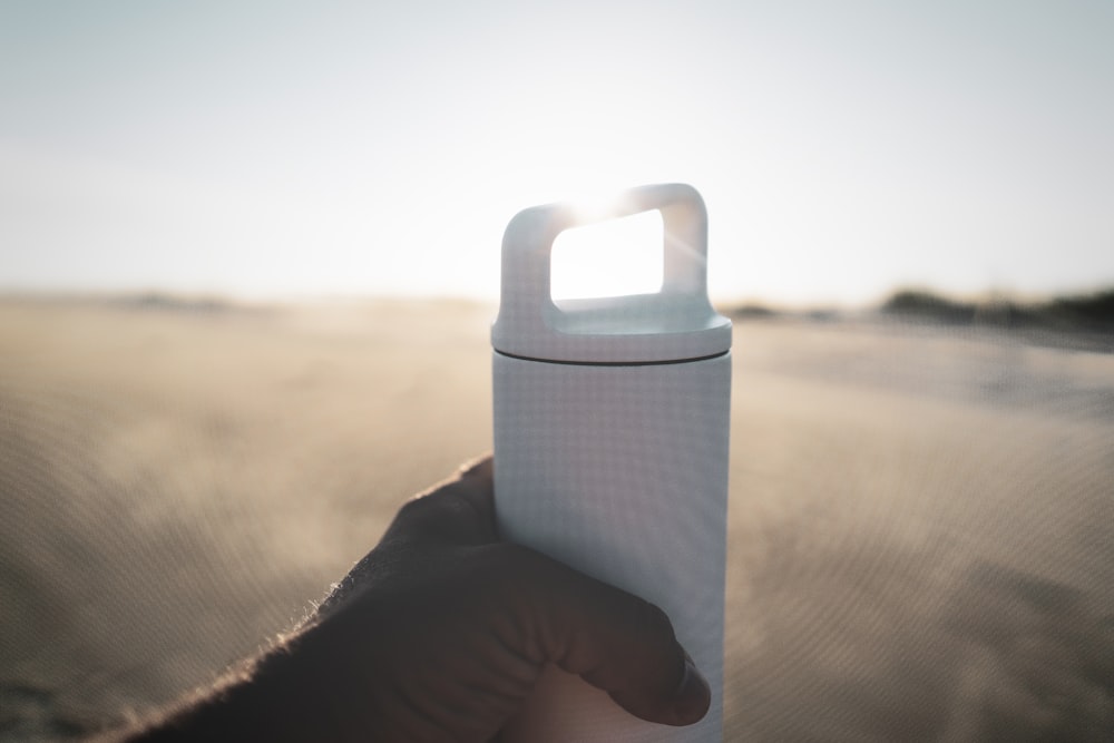 person holding white tumbler