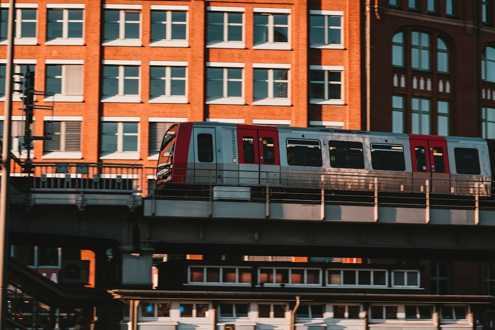 a train traveling over a bridge in front of a tall building