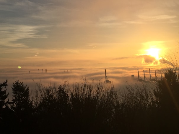 A dramatic drone shot over a misty industrial landscape in northwest England at dawn.