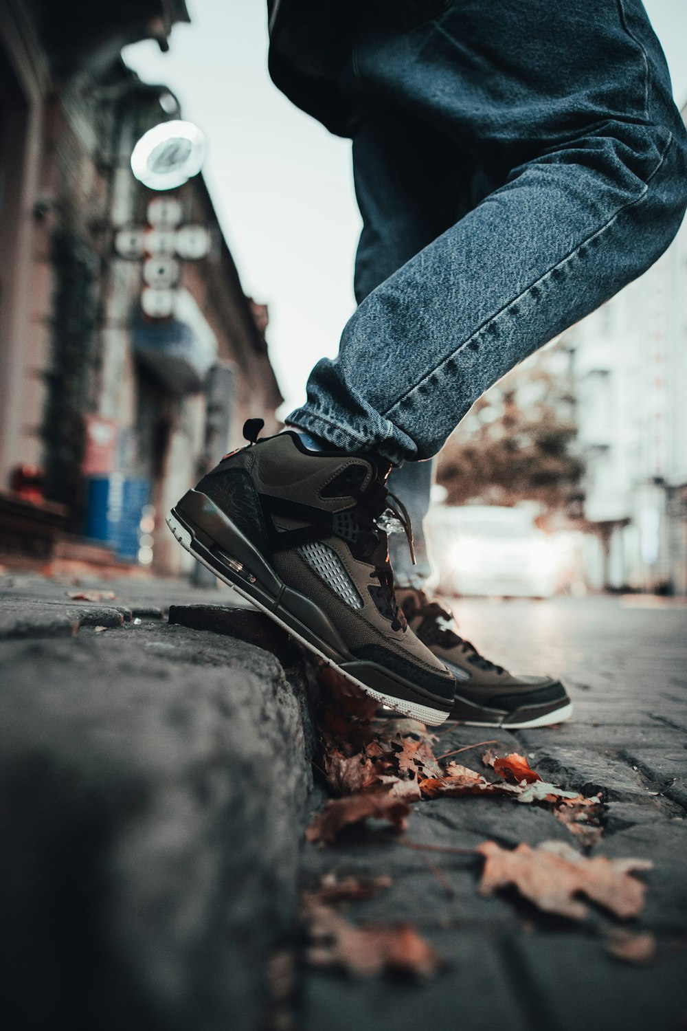 person wearing blue denim jeans and black shoes