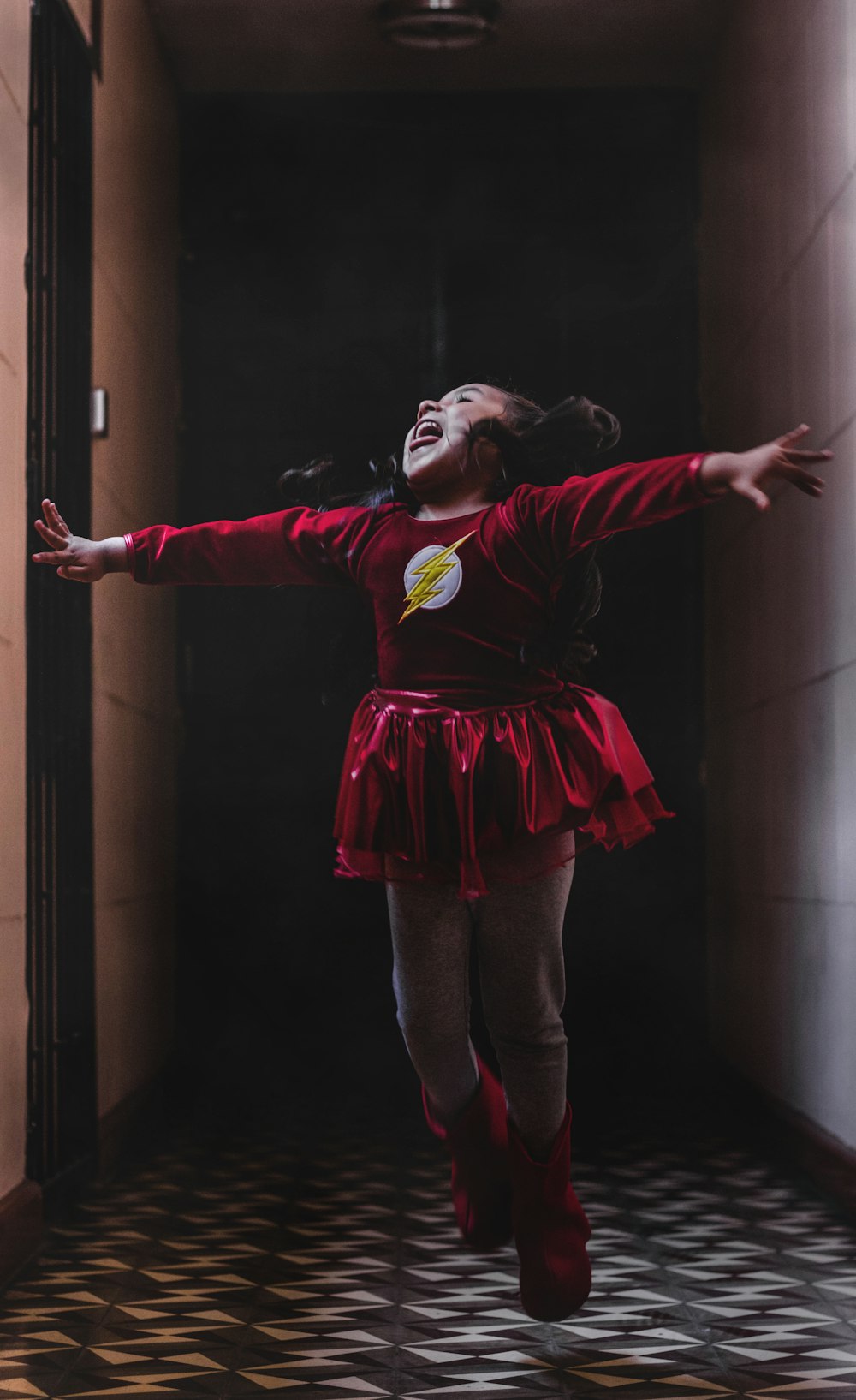 laughing and jumping girl in DC Flash costume in room