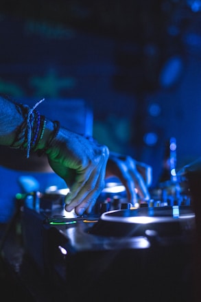 DJ at mixing console under blue stage lighting
