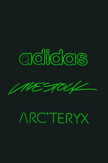 Three brand names are displayed in glowing green text against a dark background. The words are 'adidas', 'LIVESTOCK', and 'ARC'TERYX', each written in distinct styles.