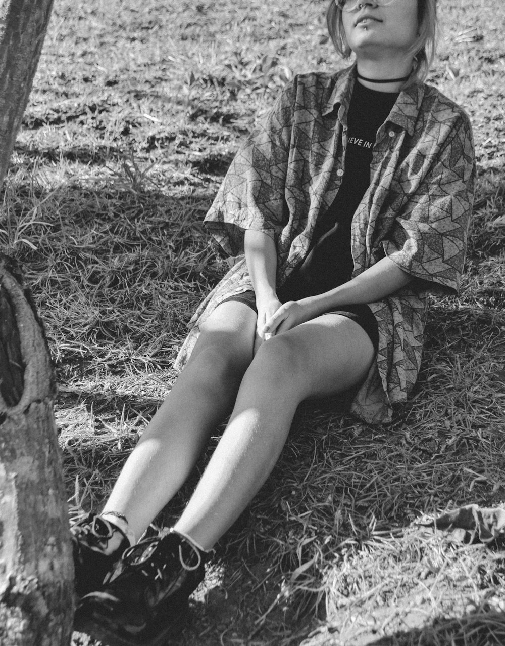 woman sitting on the ground under the tree