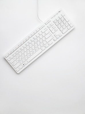 white corded computer keyboard on white surface