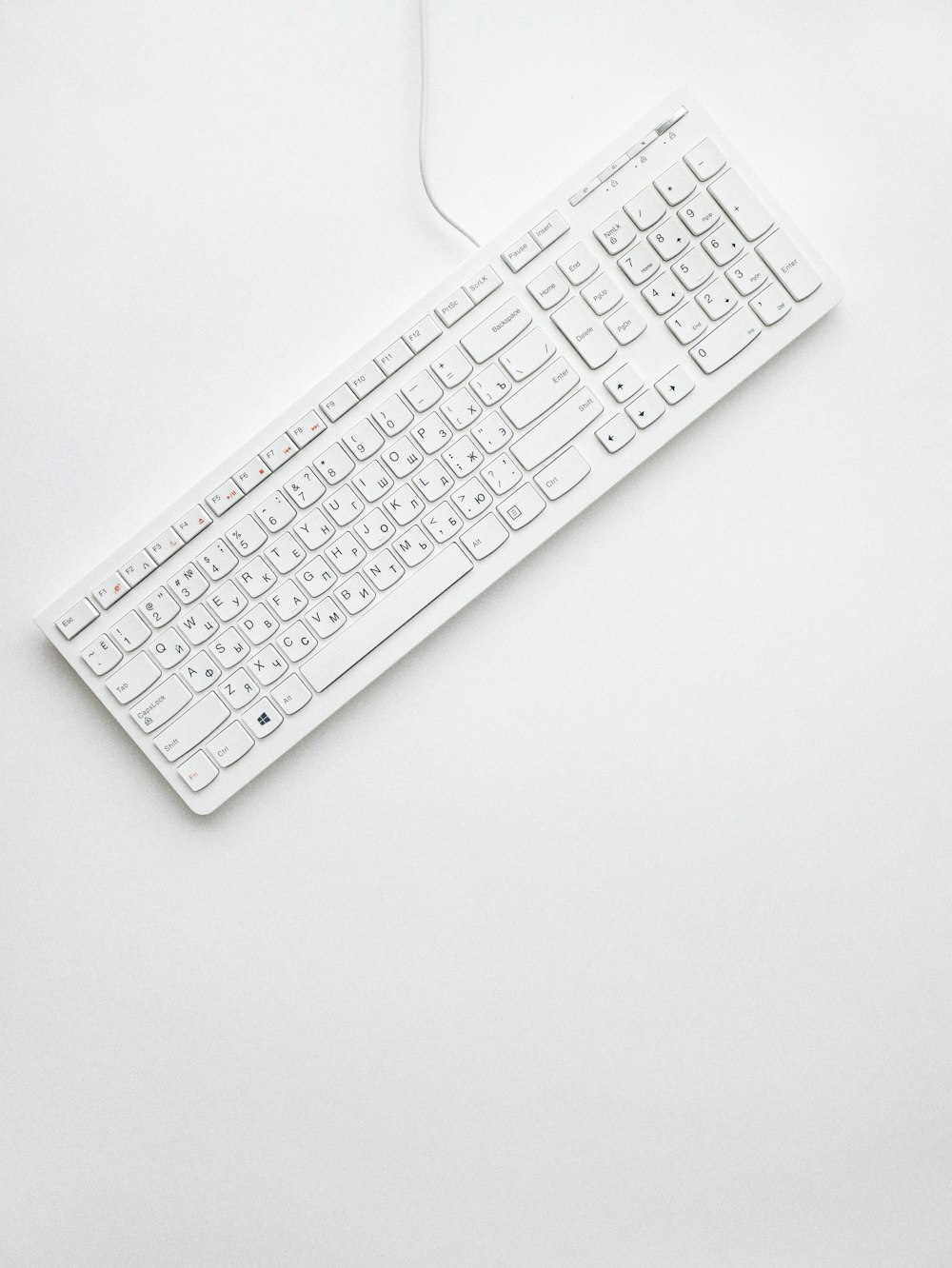 white corded computer keyboard on white surface