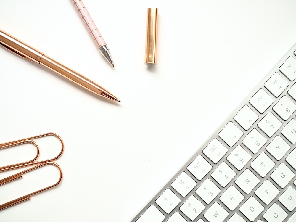 flat-lay photography of keyboard and pens