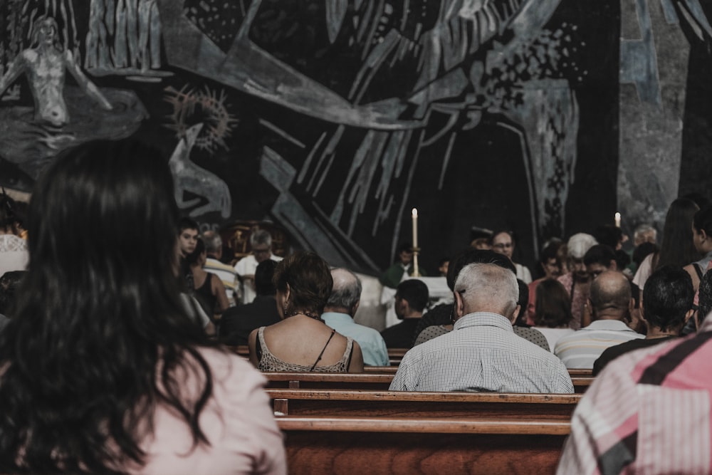 people sitting on pew bench in church