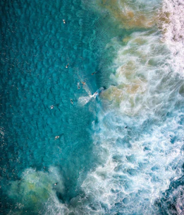 View of the turquoise waters and surfers waiting at the 'derechón' wave on Lobos Island.