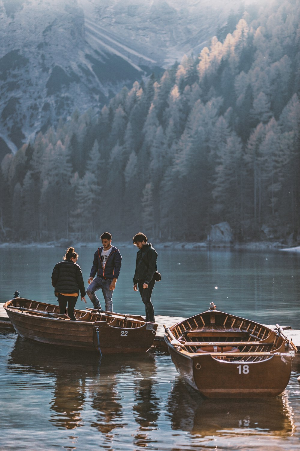 three person in dock near the boat during daytime