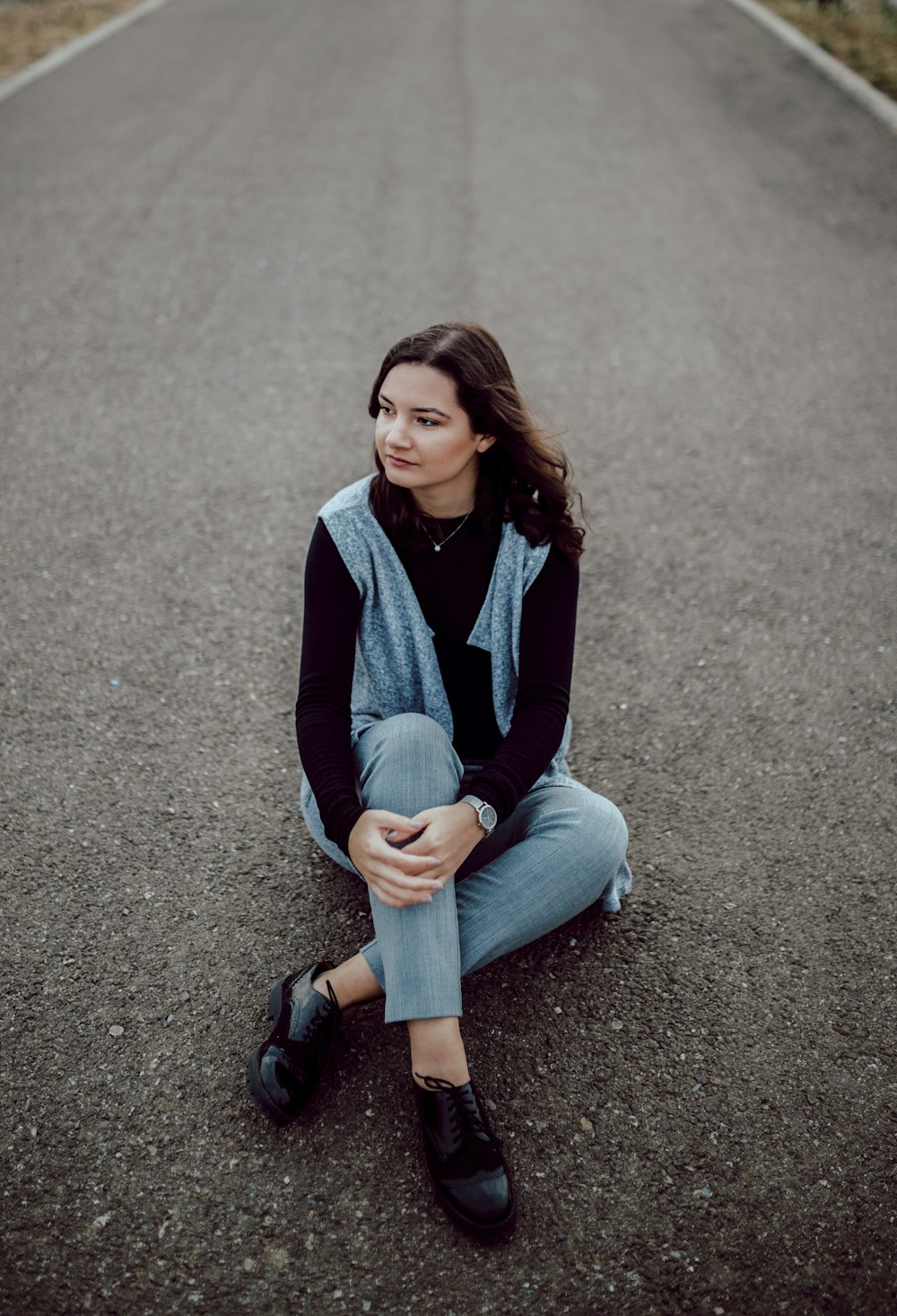 woman sitting on concrete road