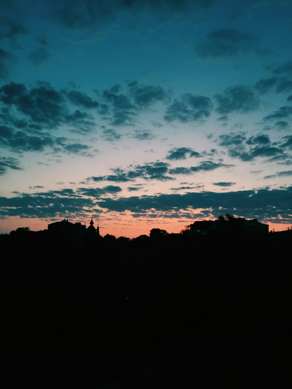 silhouette of building under cloudy sky