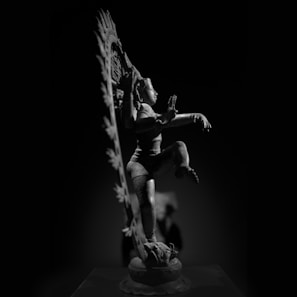 Bronze sculpture of a graceful dancer captured mid-movement on a wooden base