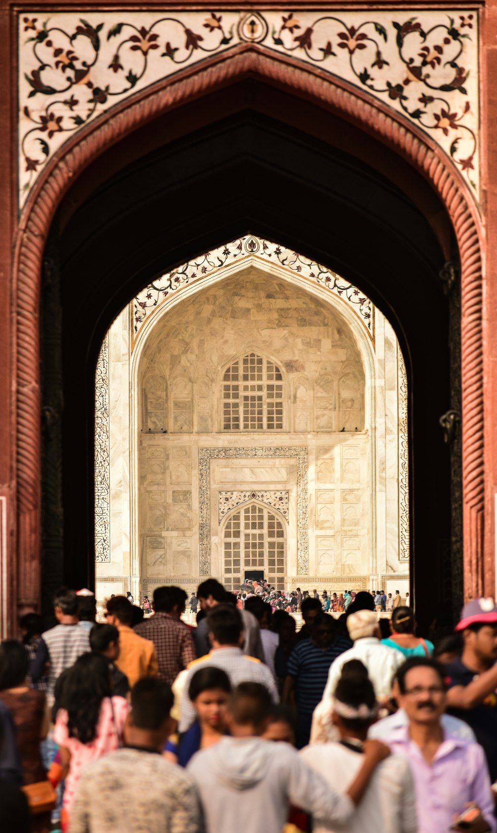 group of people passing below arch during daytime