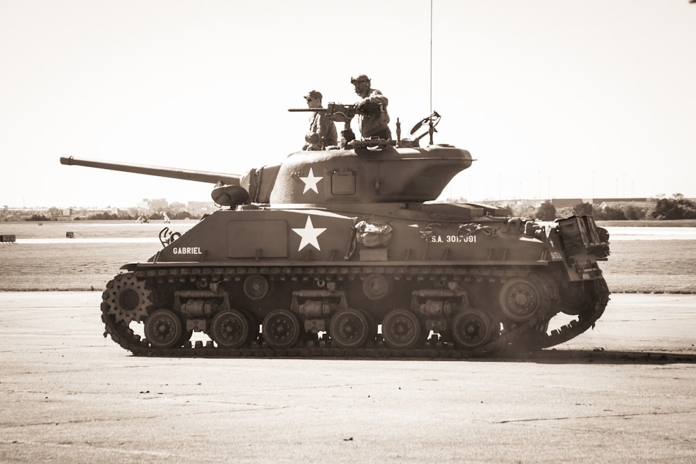 Dos personas montadas en un tanque de batalla