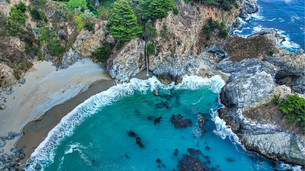 aerial photography of waves splashing by the seashore