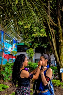 A peaceful scene showing a person receiving jagua body painting surrounded by natural elements.